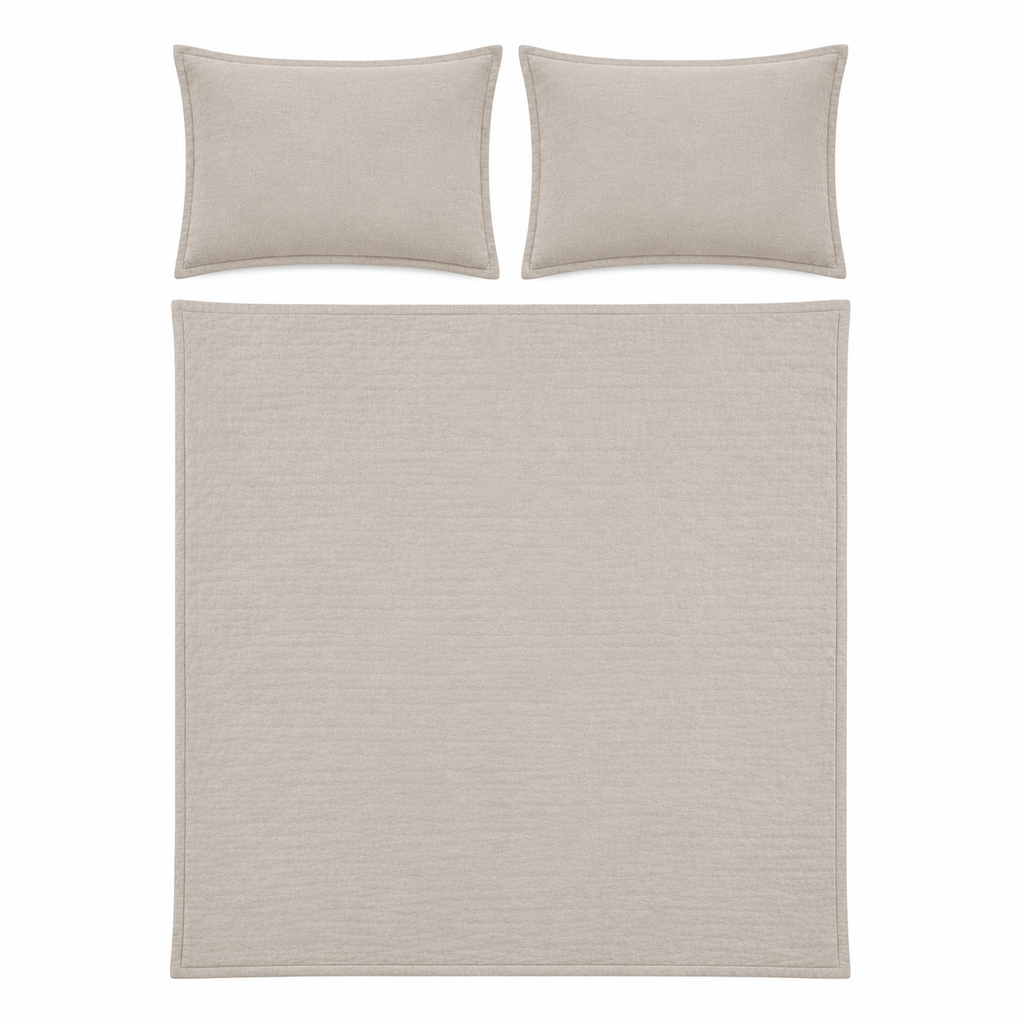 A bedding set featuring a textured quilt and two matching pillowcases in a light beige color, displayed on a solid white background.