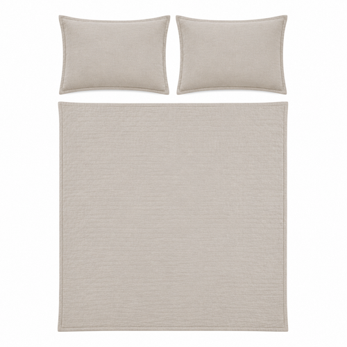 A bedding set featuring a textured quilt and two matching pillowcases in a light beige color, displayed on a solid white background.