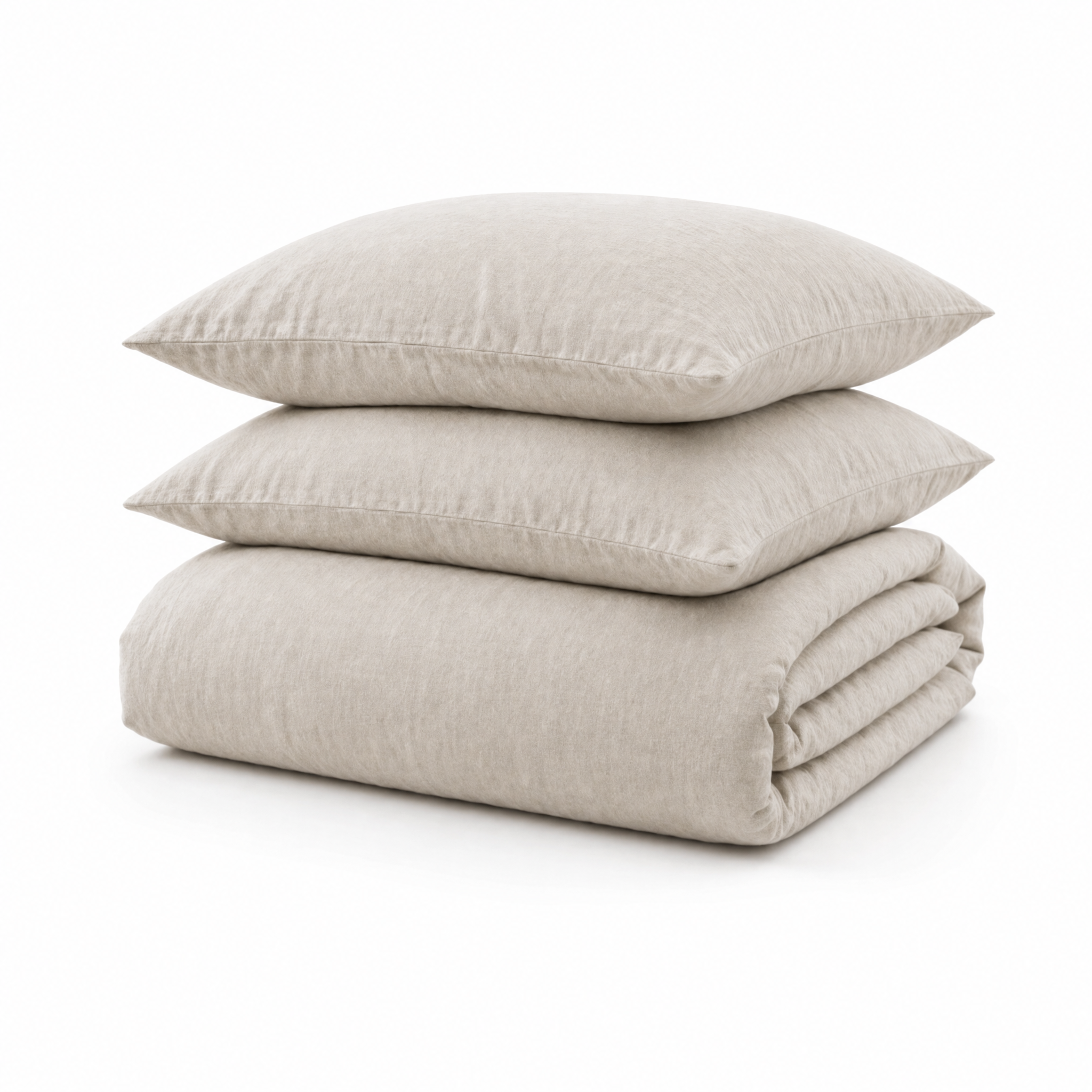 A stack of three light beige linen bedding pieces, including two pillows and a folded duvet cover, on a white background.